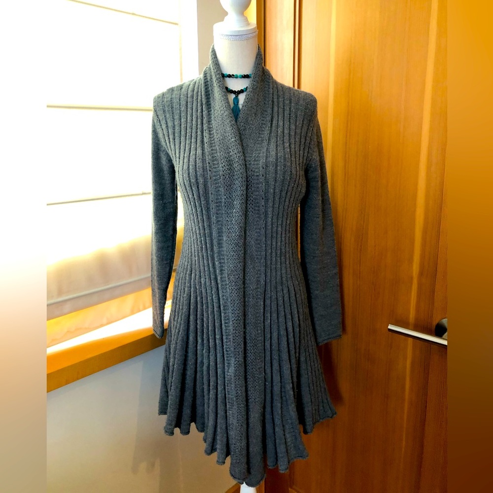 Grey cardigan sweater with unique design at bottom.